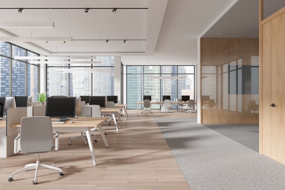 Modern empty open-plan office with desks, chairs and large windows, representing commercial premises at lease end.